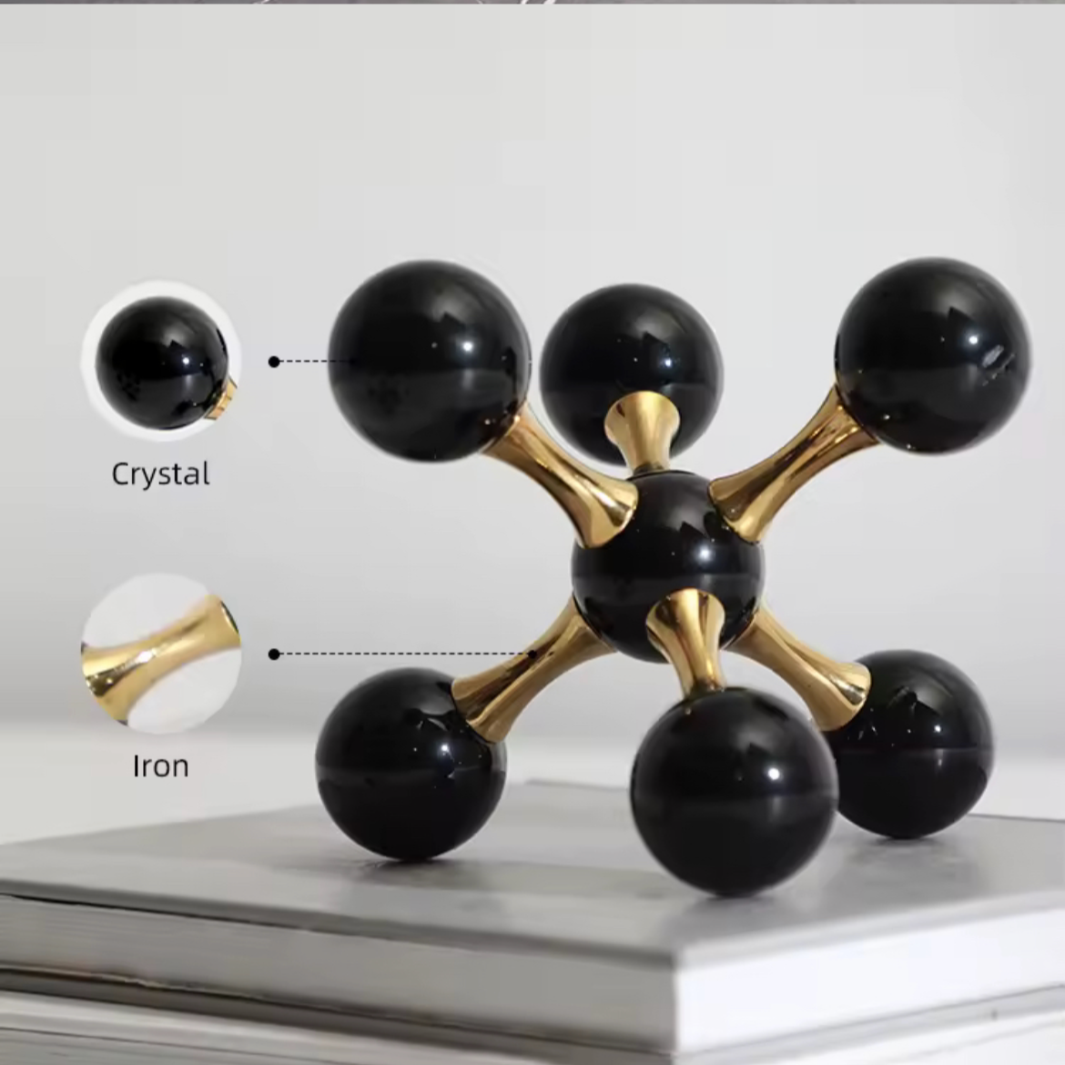 Decorative black and gold sculpture on a white surface with product details displayed.